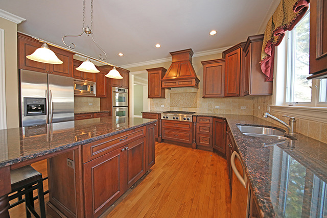 527 Ranch Road Wheaton, IL 60187 - Photo 6 of 25 a kitchen with stainless steel appliances granite countertop a refrigerator a sink and wooden cabinets
