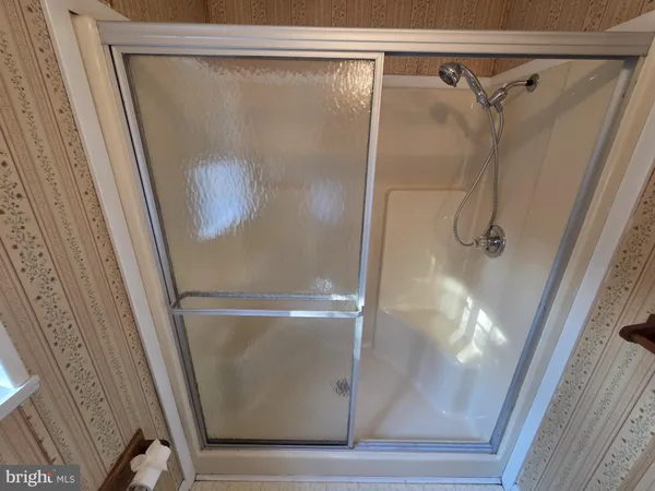 a bathroom with a sink a toilet and shower a mirror