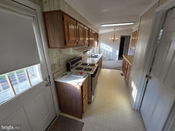 a view of a kitchen with fridge and wooden floor