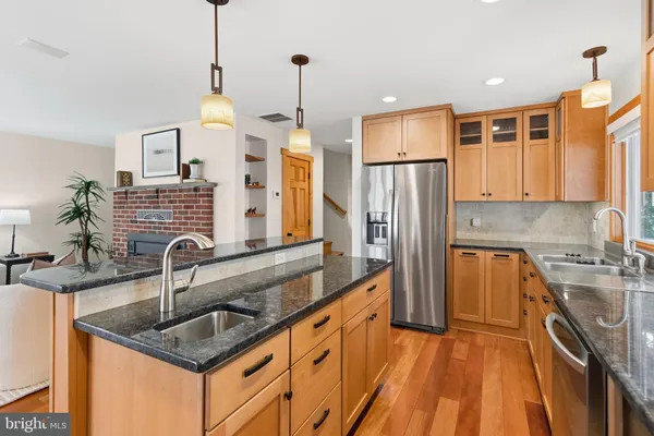 a kitchen with a sink a center island a stove and a window