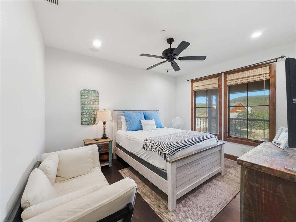 2033 Harbor Way, Unit 302 Graford, TX 76449 - Photo 18 of 28 a bedroom with a large bed and a chandelier