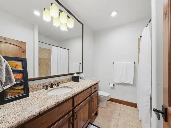 a bathroom with a granite countertop double vanity sink and a mirror