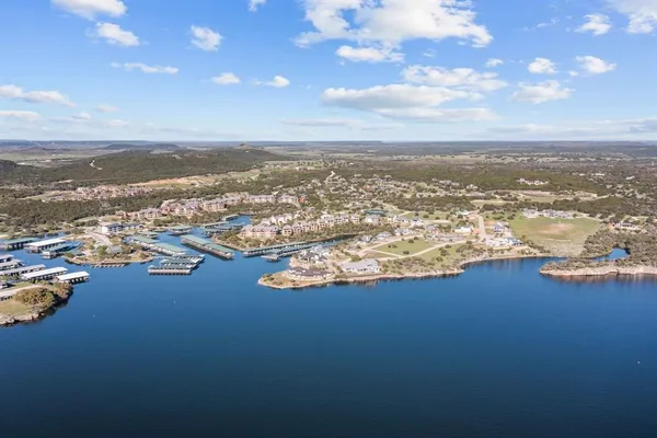an aerial view of ocean and residential houses with outdoor space