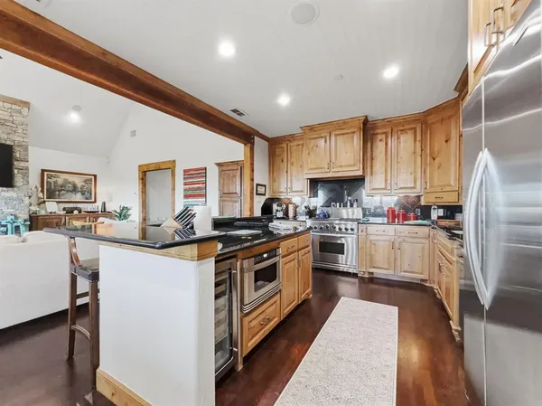 a kitchen with stainless steel appliances granite countertop a stove refrigerator sink and cabinets