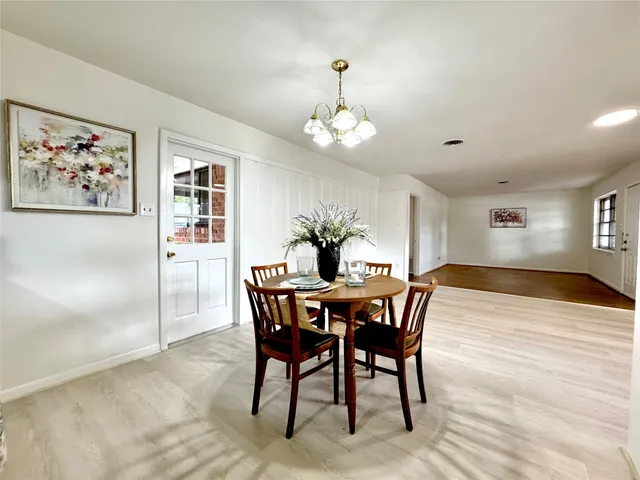 a view of a dining room with furniture a chandelier and wooden floor