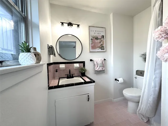 a bathroom with a toilet a sink and a mirror