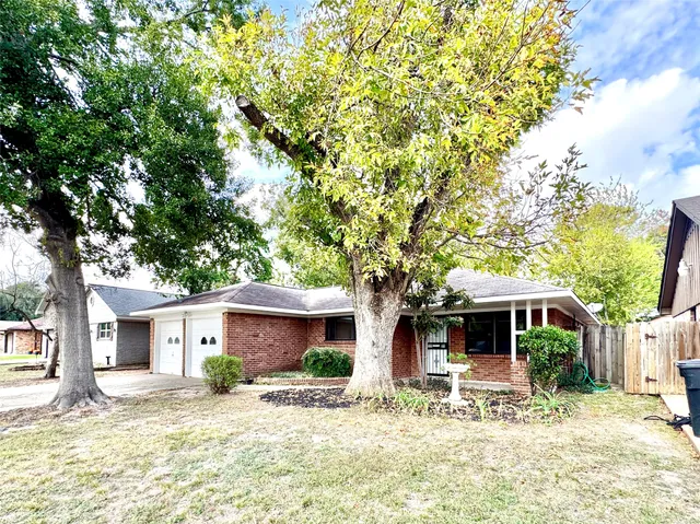 a front view of a house with a yard and potted plants