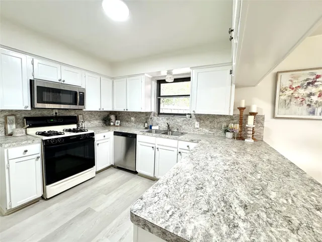 a kitchen with a stove a sink and a microwave