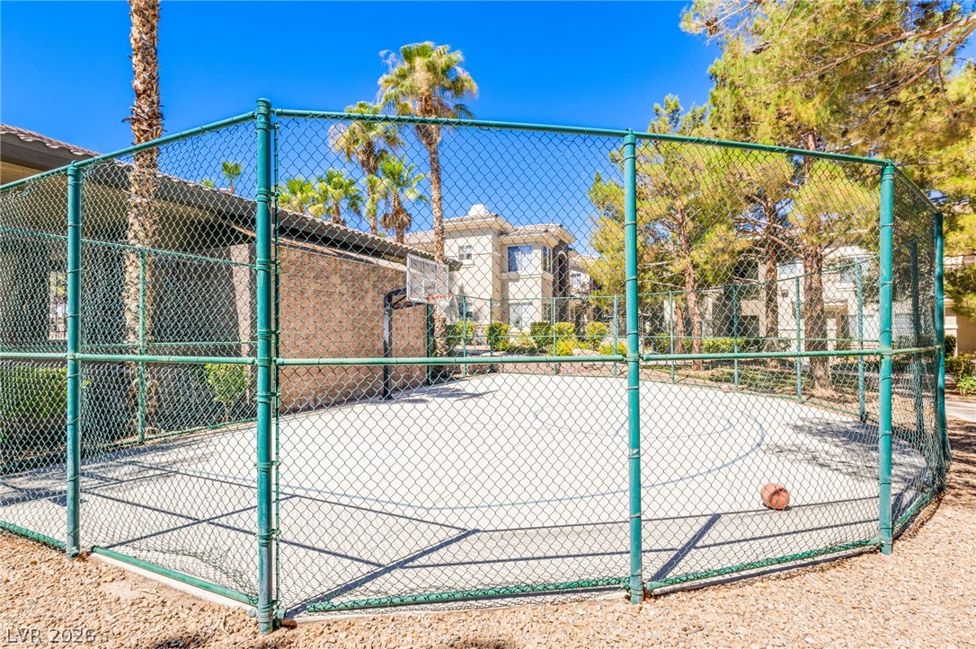 9050 West Warm Springs Road, Unit 1011 Las Vegas, NV 89148 - Photo 28 of 32 A well-maintained basketball court is available for residents, surrounded by lush landscaping and mature palm trees.
