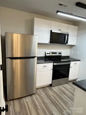 a kitchen with stainless steel appliances a refrigerator stove and microwave