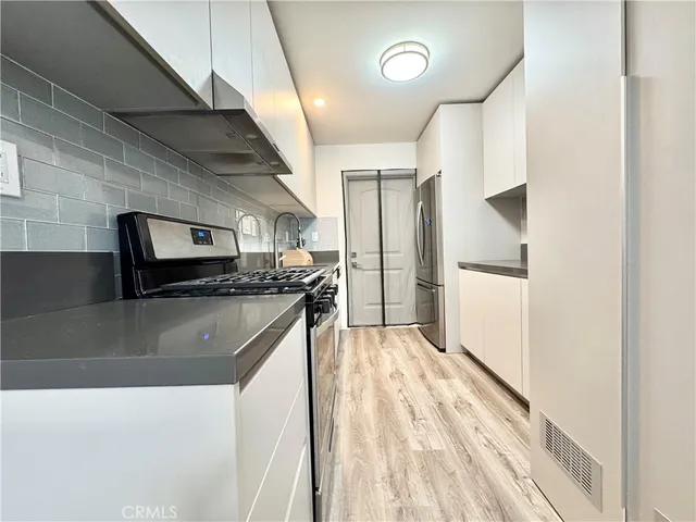 a kitchen with stainless steel appliances granite countertop a refrigerator and a sink