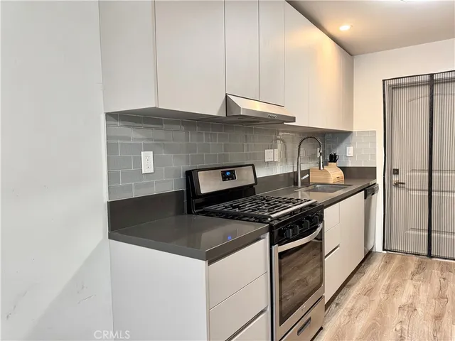 a kitchen with stainless steel appliances granite countertop a stove and a refrigerator