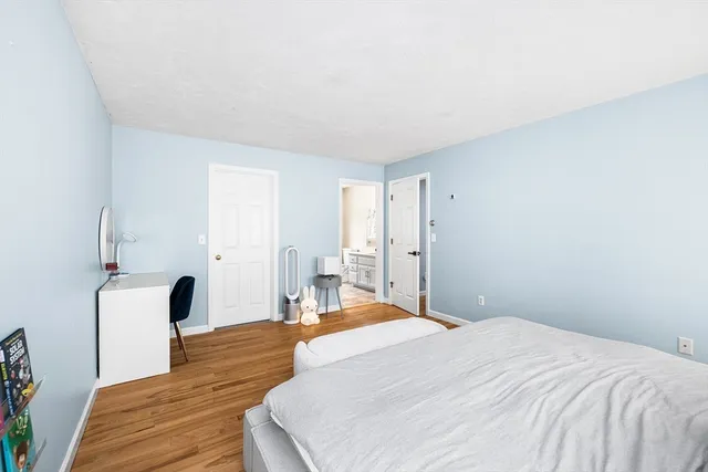 a bedroom with a bed and wooden floor