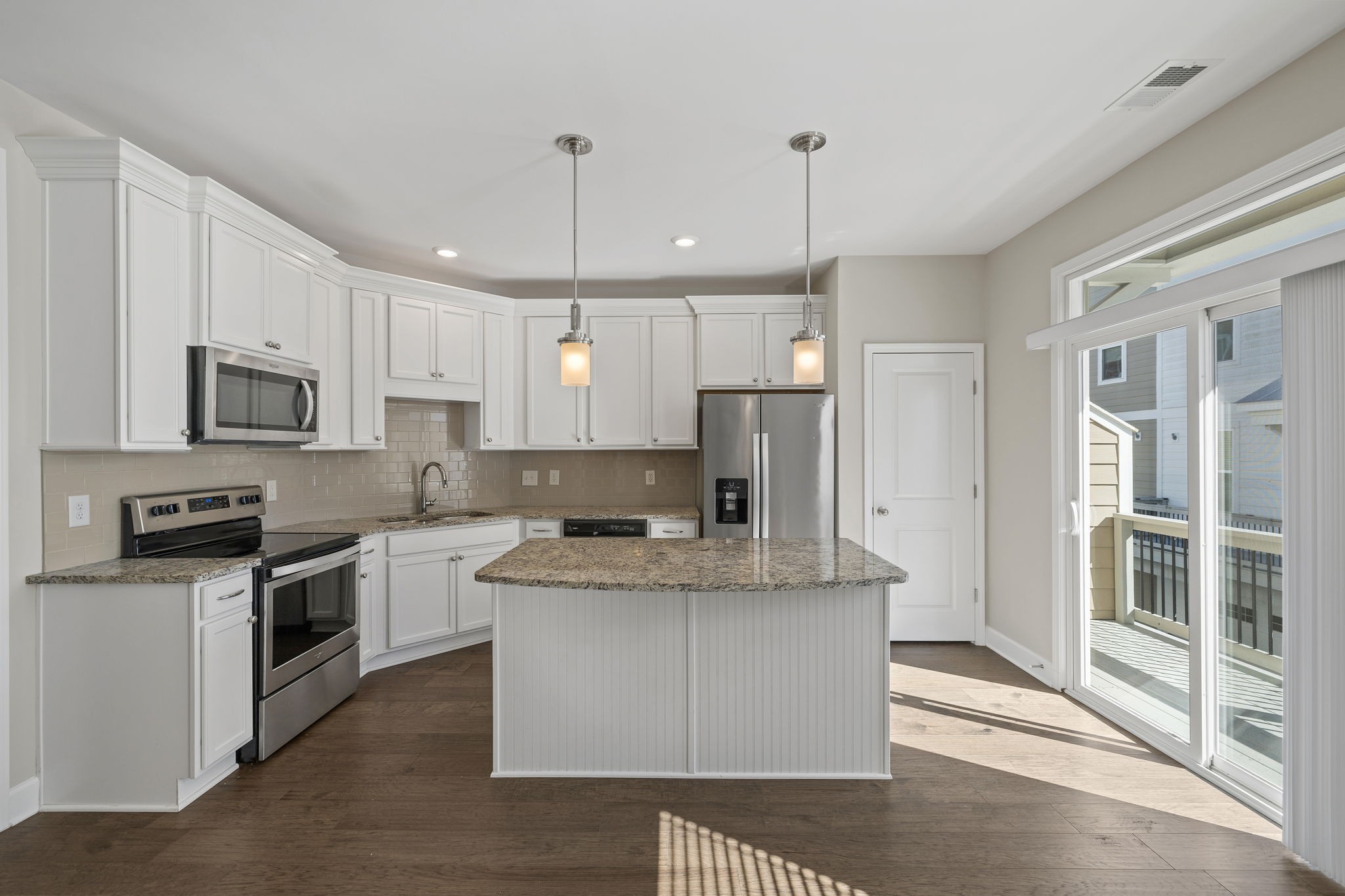 a kitchen with stainless steel appliances granite countertop a stove a sink a refrigerator a center island and cabinets