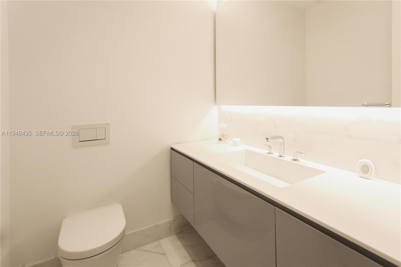 6901 Collins Avenue, Unit 901 Miami Beach, FL 33141 - Photo 15 of 21 a bathroom with a sink a toilet and mirror