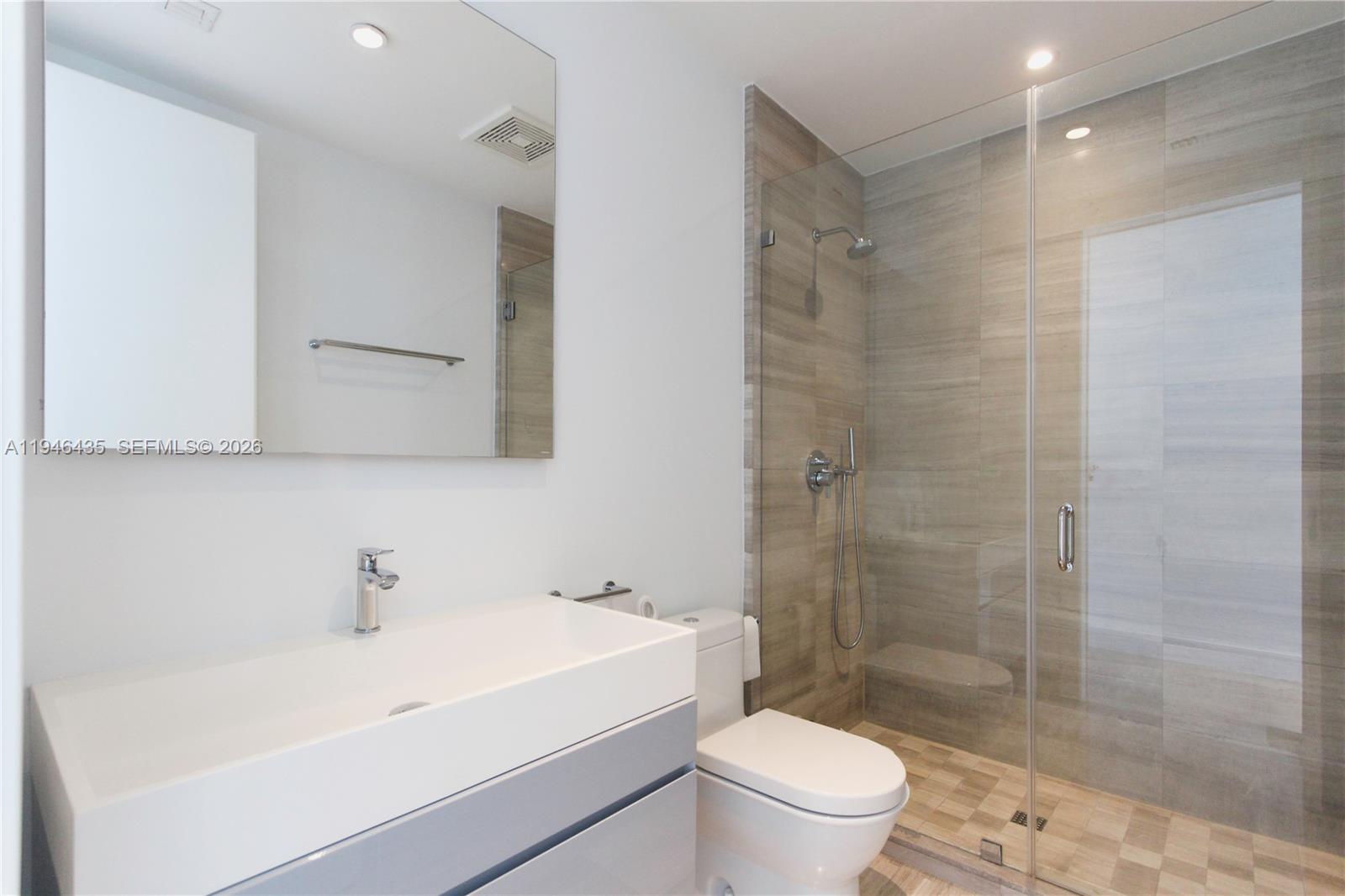 6901 Collins Avenue, Unit 901 Miami Beach, FL 33141 - Photo 17 of 21 a bathroom with a sink a toilet and shower