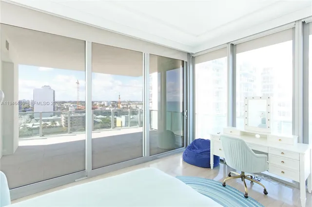 a spacious bedroom with a large window and a couch