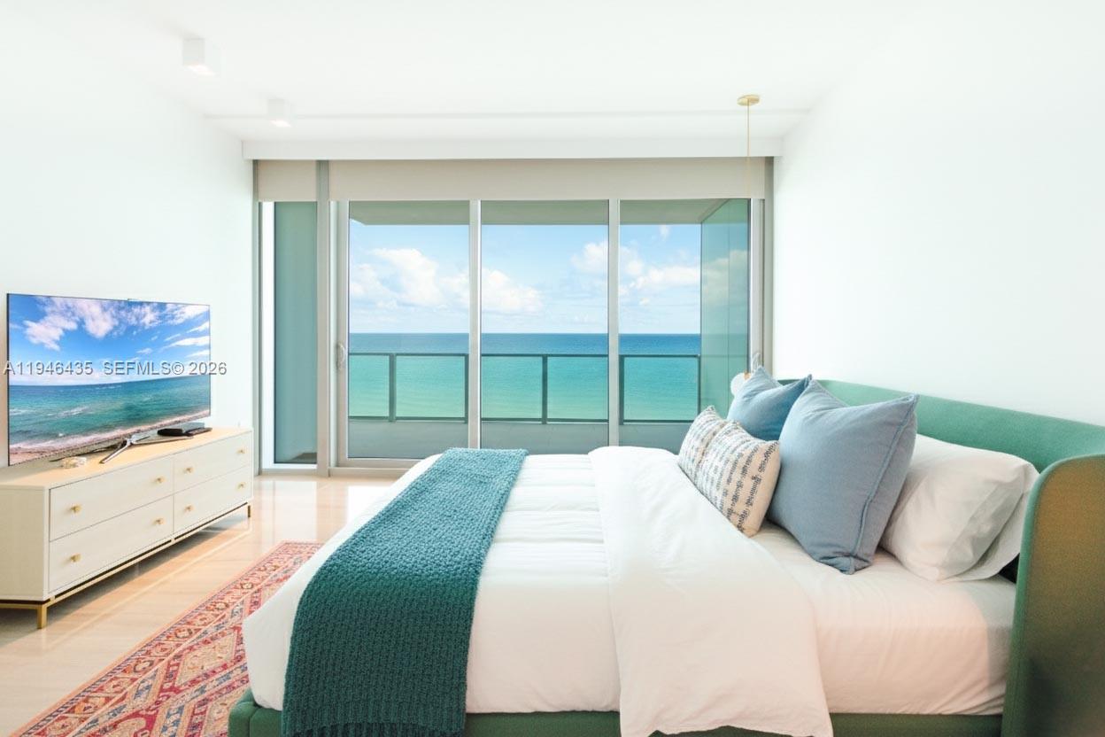 6901 Collins Avenue, Unit 901 Miami Beach, FL 33141 - Photo 8 of 21 a bedroom with a bed and a flat tv screen on dresser