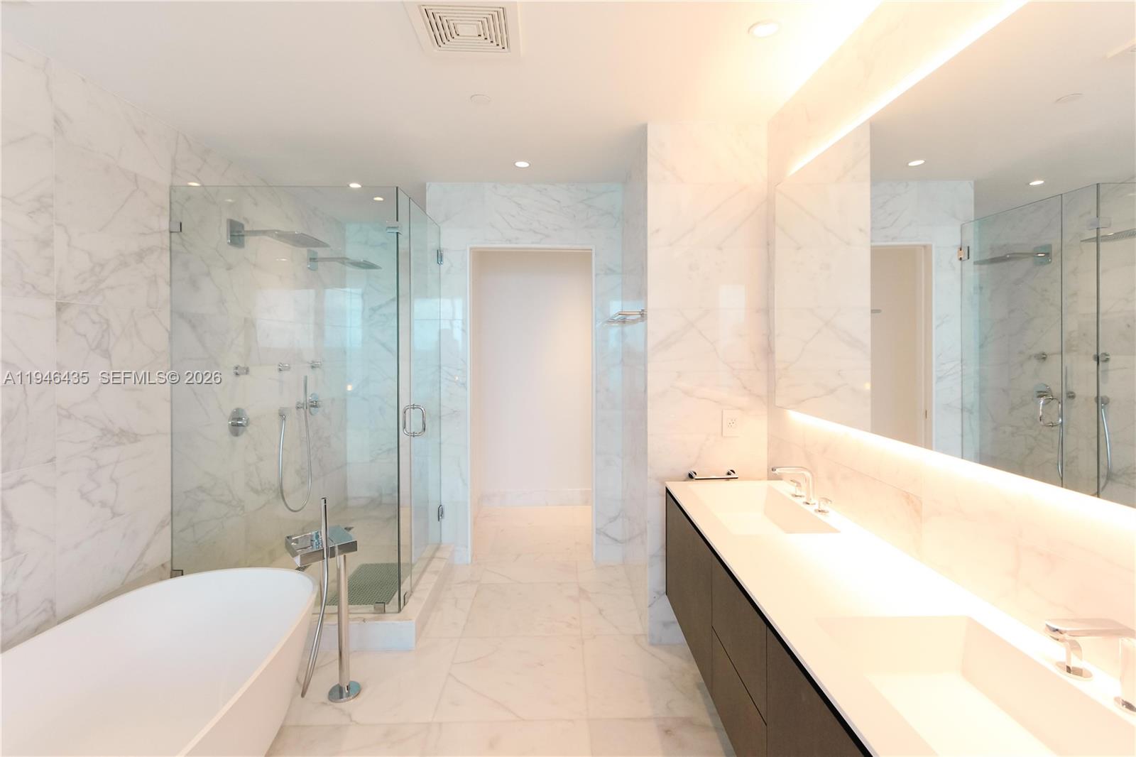 6901 Collins Avenue, Unit 901 Miami Beach, FL 33141 - Photo 10 of 21 a bathroom with a tub a sink a mirror and a shower