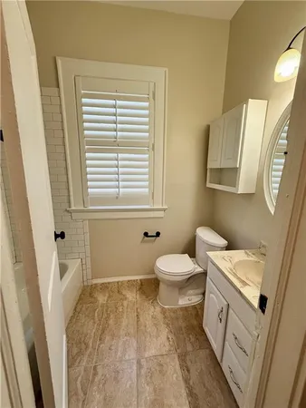 a bathroom with a sink a toilet and a window