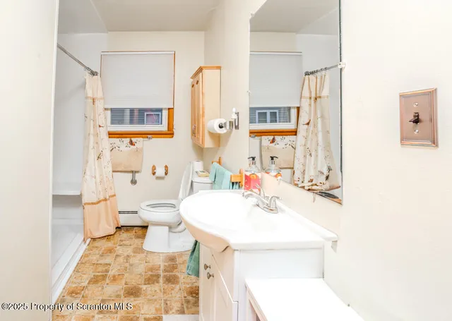 a bathroom with a sink a toilet and a mirror