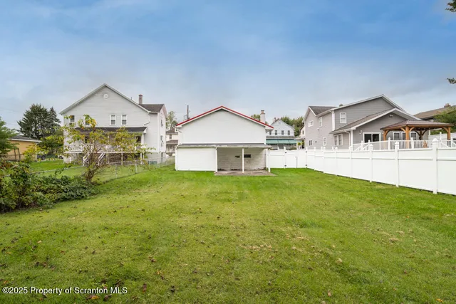 a view of a big house with a big yard and large trees