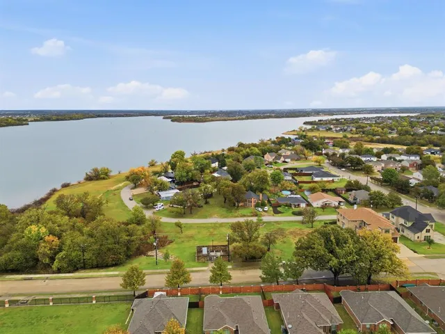 an aerial view of ocean with residential houses with outdoor space