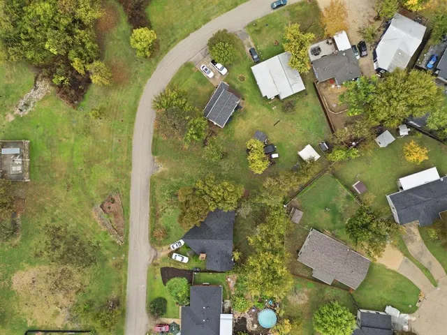 an aerial view of a residential houses with yard