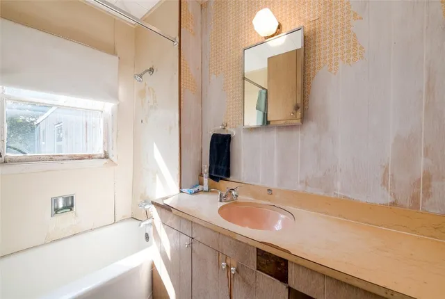 a bathroom with a tub sink and mirror