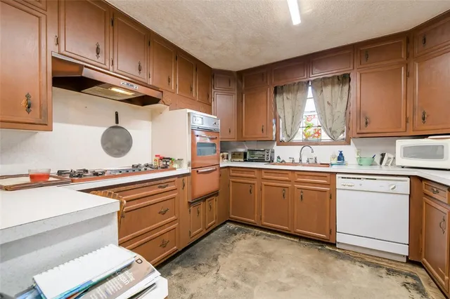 a kitchen with stainless steel appliances granite countertop a sink stove and cabinets