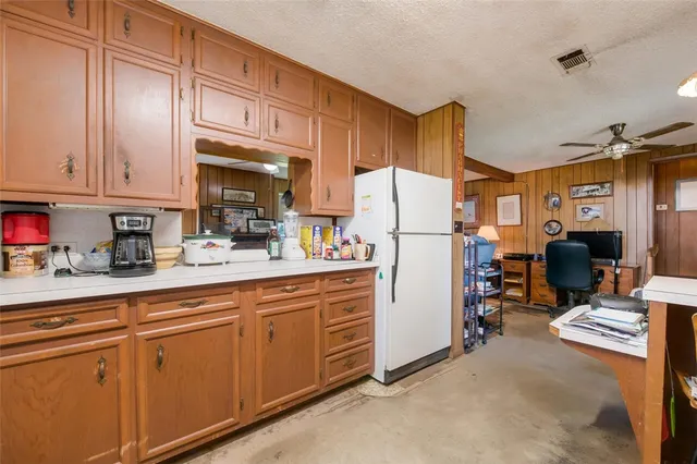 a kitchen with refrigerator and cabinets
