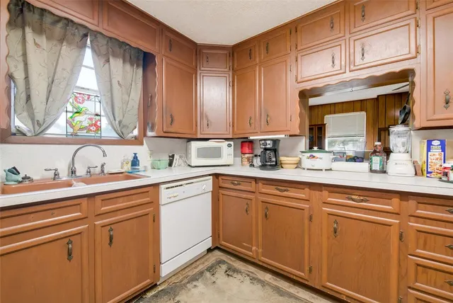 a kitchen with stainless steel appliances granite countertop a sink a stove and cabinets