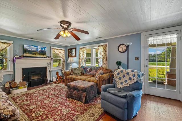 a living room with furniture a fireplace and a large window