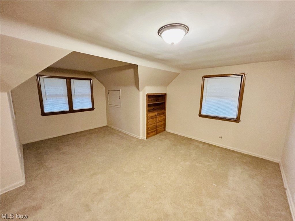 13414 Rockside Road Garfield Heights, OH 44125 - Photo 13 of 25 Additional living space featuring vaulted ceiling and light carpet