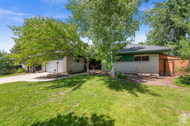 1665 Fieldcrest Lane Holladay, UT 84117 - Photo 1 of 1 View of front of property featuring concrete driveway, a front yard, and an attached garage