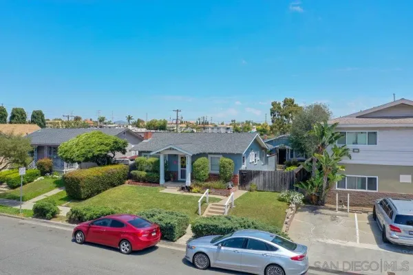 a front view of a house with a garden and parking