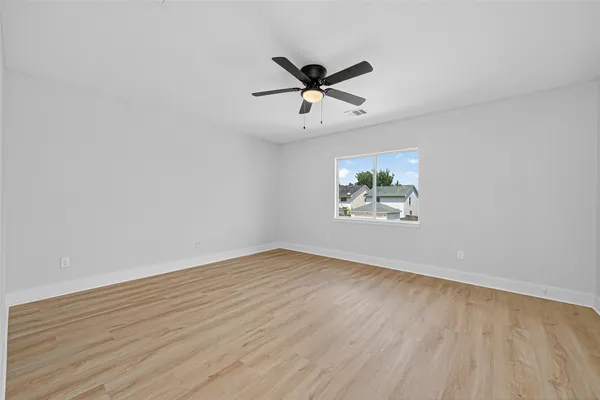 a view of empty room with wooden floor