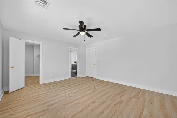 a spacious bathroom with a double vanity sink a large mirror and a toilet