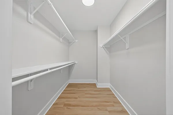 a view of a hallway with wooden floor and a window