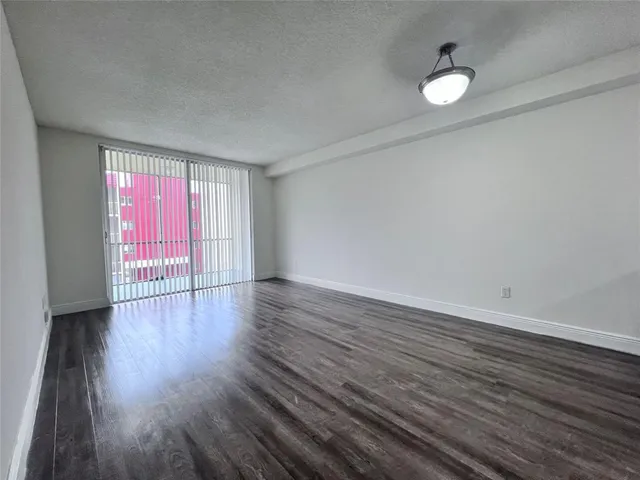 a view of a livingroom with wooden floor and window