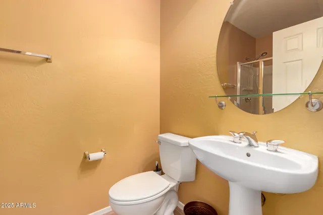 a bathroom with a sink mirror and toilet