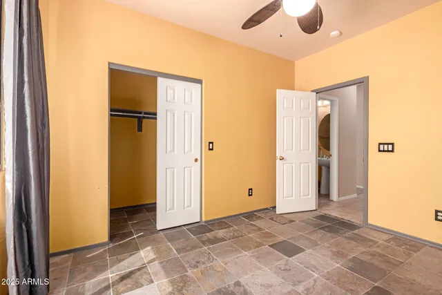 a view of a hallway with closet and a bathroom