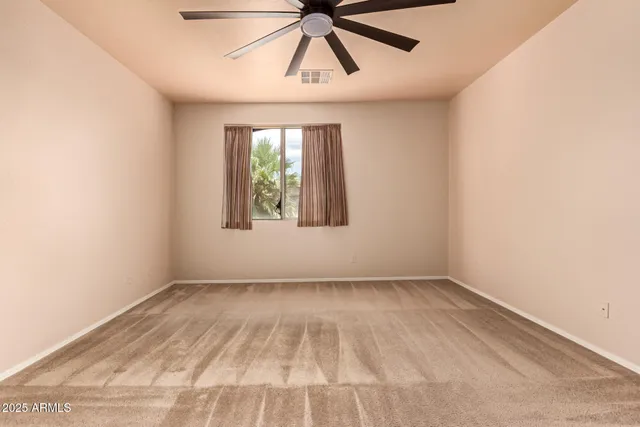 an empty room with a window and a ceiling fan