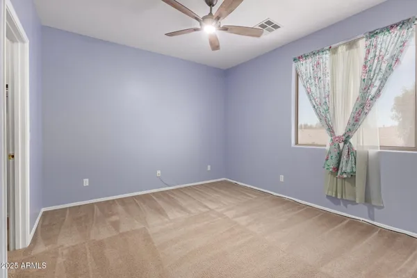 an empty room with a ceiling fan and a window