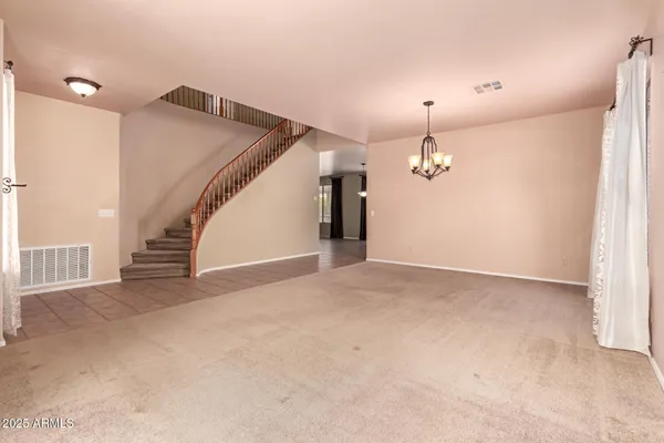 a view of a livingroom with wooden floor and stairs