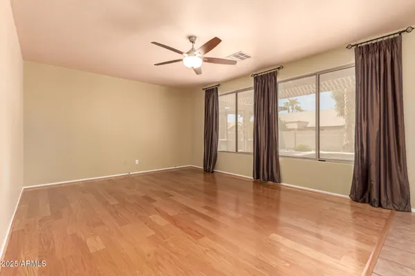 an empty room with windows and fan