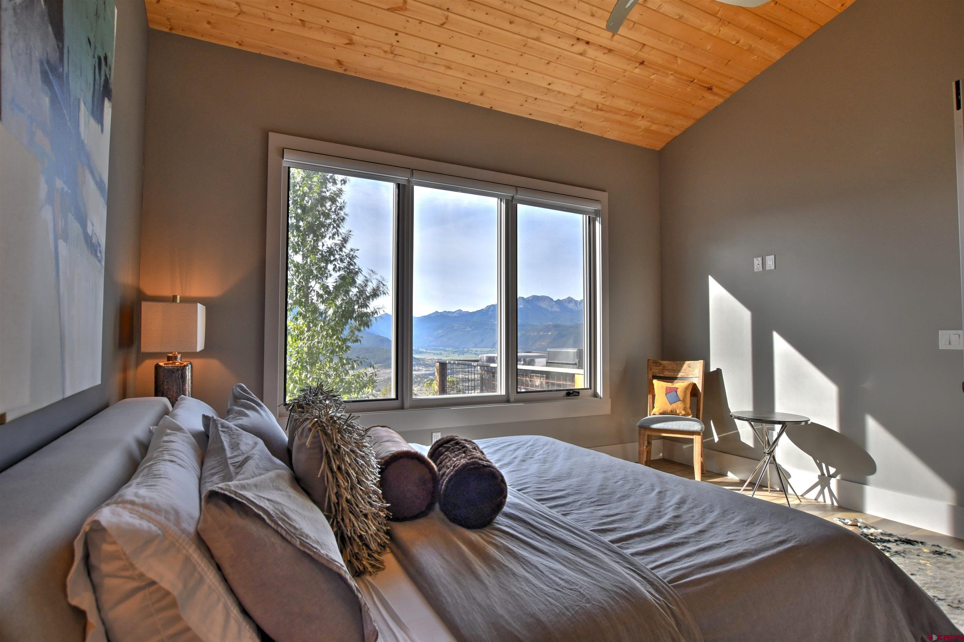 150 Enclave Road Ridgway, CO 81432 - Photo 13 of 45 a bedroom with a bed and large windows