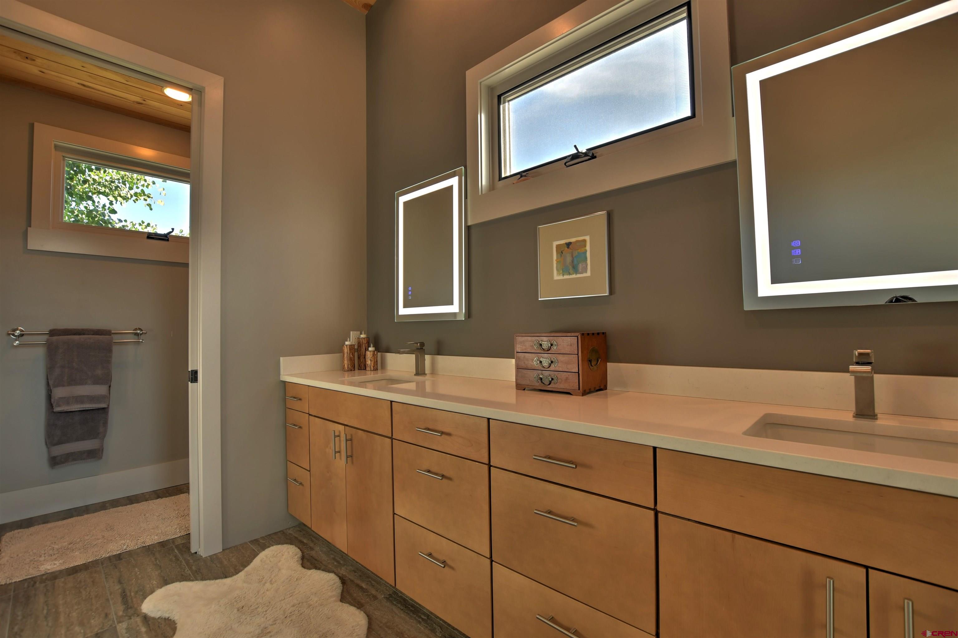 150 Enclave Road Ridgway, CO 81432 - Photo 16 of 45 a bathroom with a granite countertop sink mirror and vanity