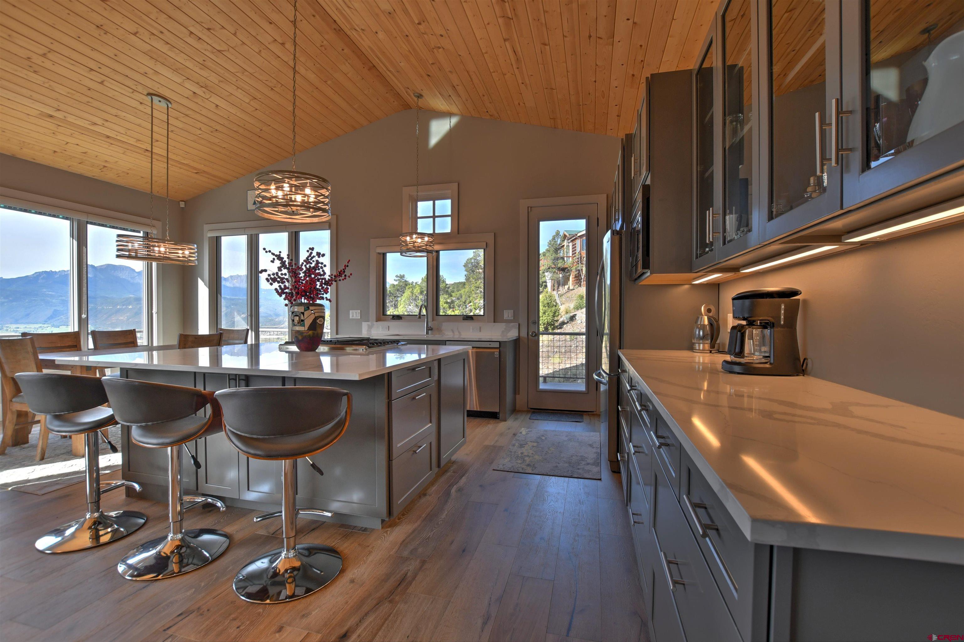 150 Enclave Road Ridgway, CO 81432 - Photo 2 of 45 a kitchen with a dining table chairs and granite counter top