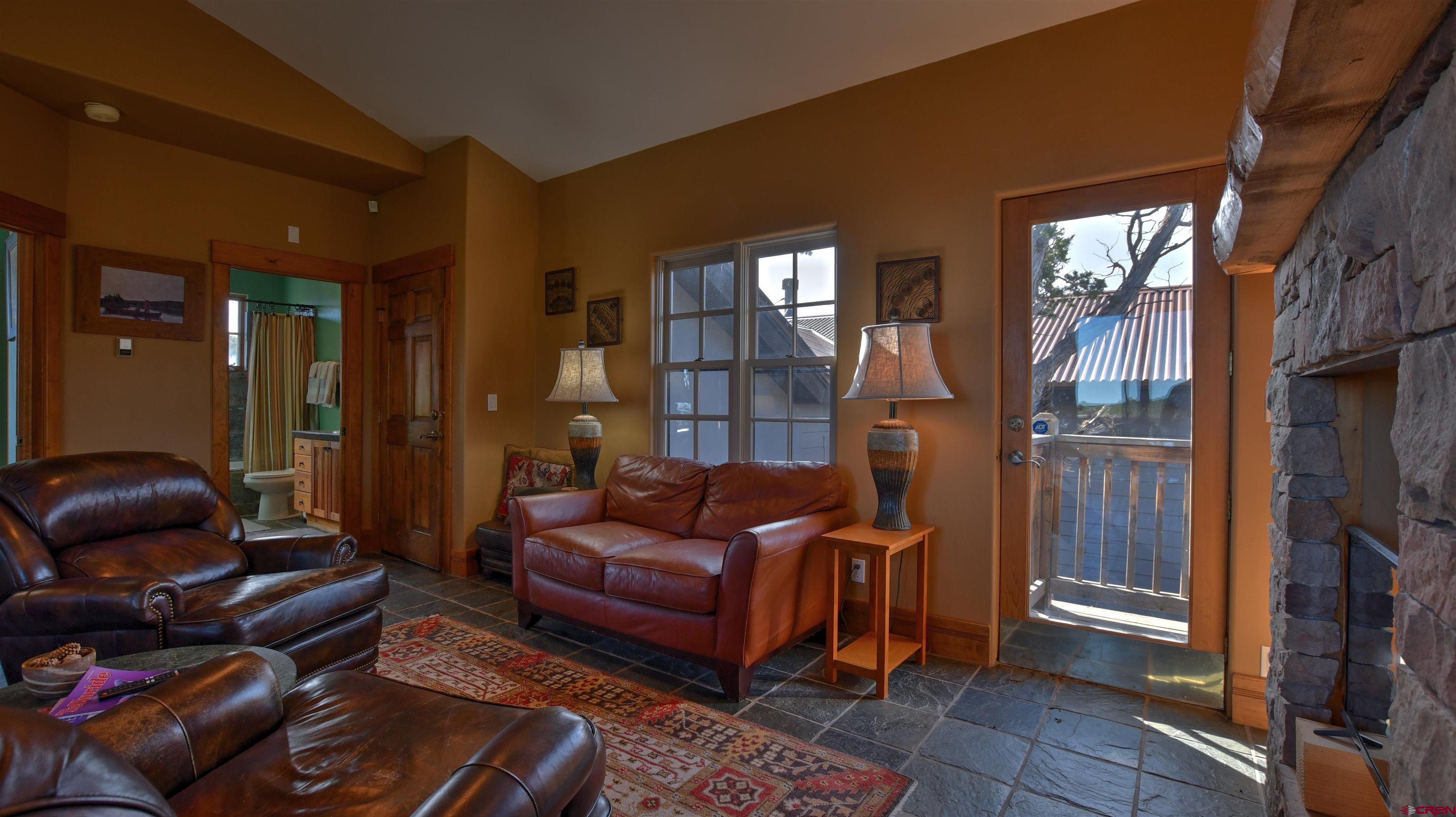 150 Enclave Road Ridgway, CO 81432 - Photo 28 of 45 a living room with furniture a lamp and a fireplace